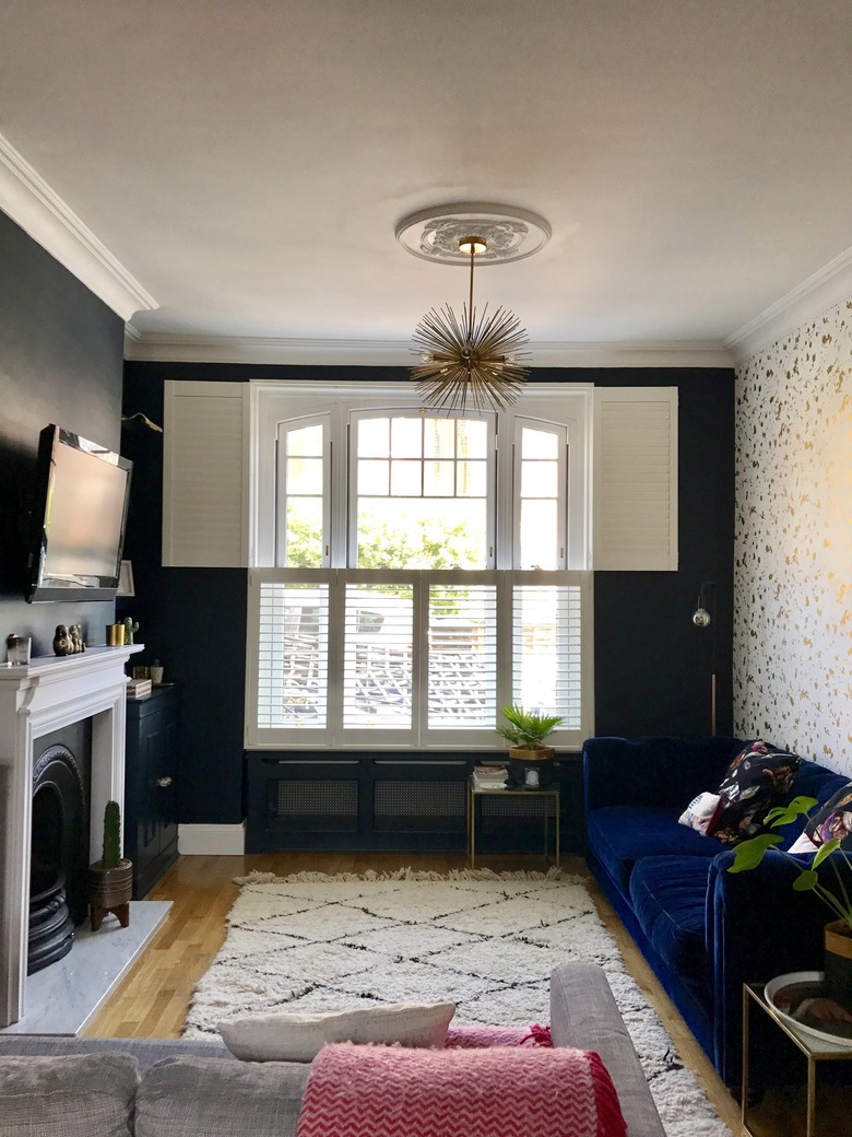 dark blue living room with white and gold feature wall