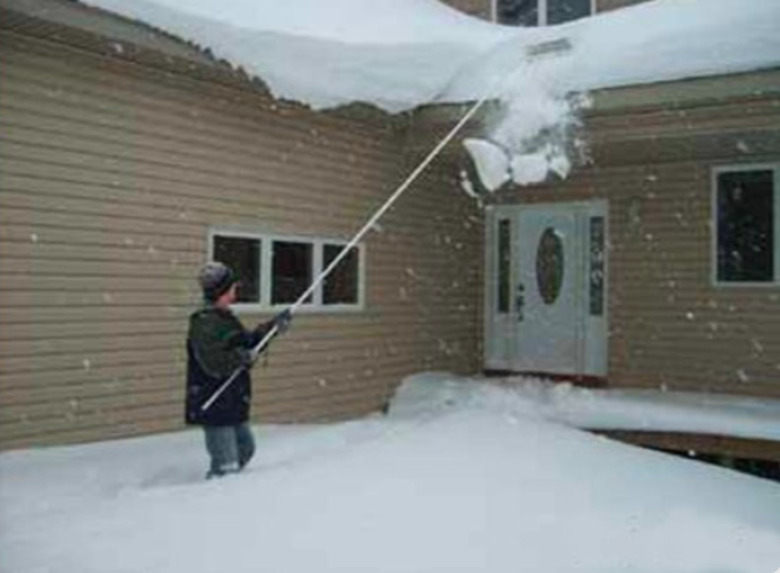 Raking snow from the roof.