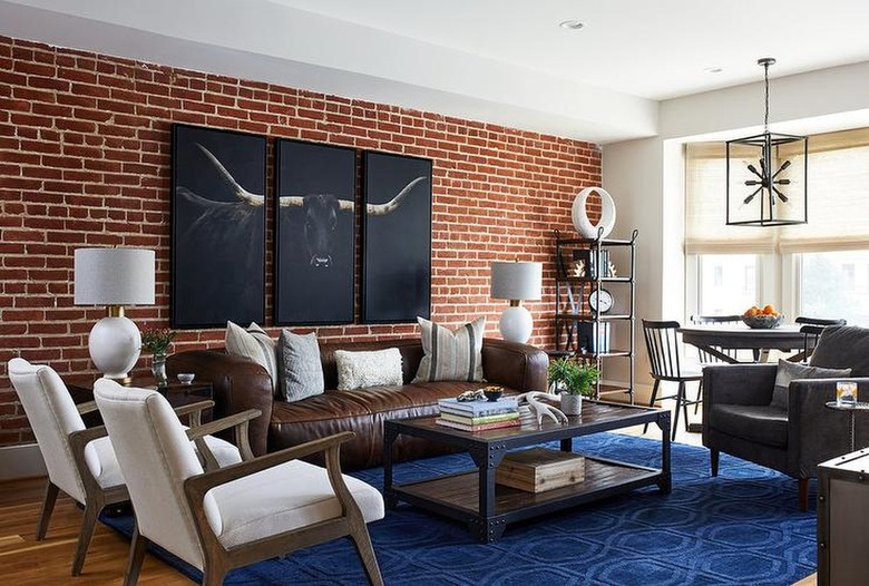 brown leather sofa against a brick wall