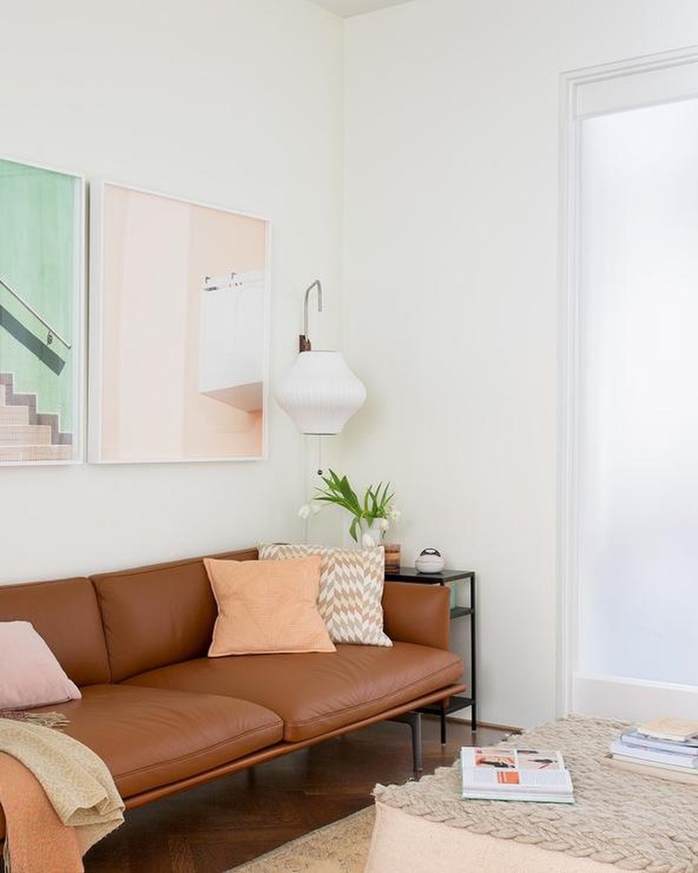 living room with brown leather sofa and peach pillow