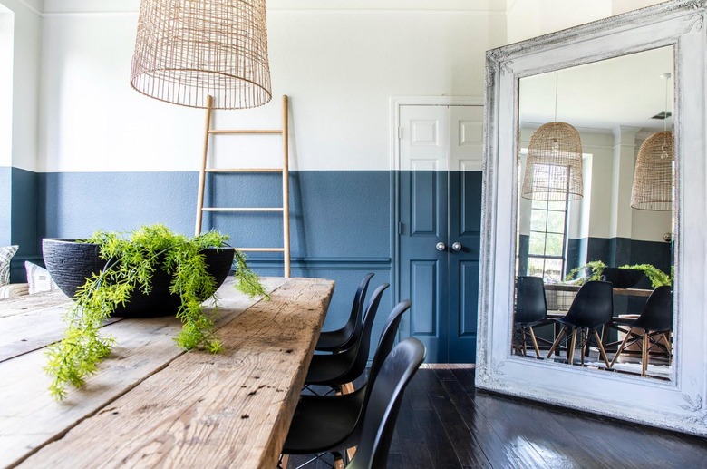 Dining room with wall that is cream on top and navy at the bottom.