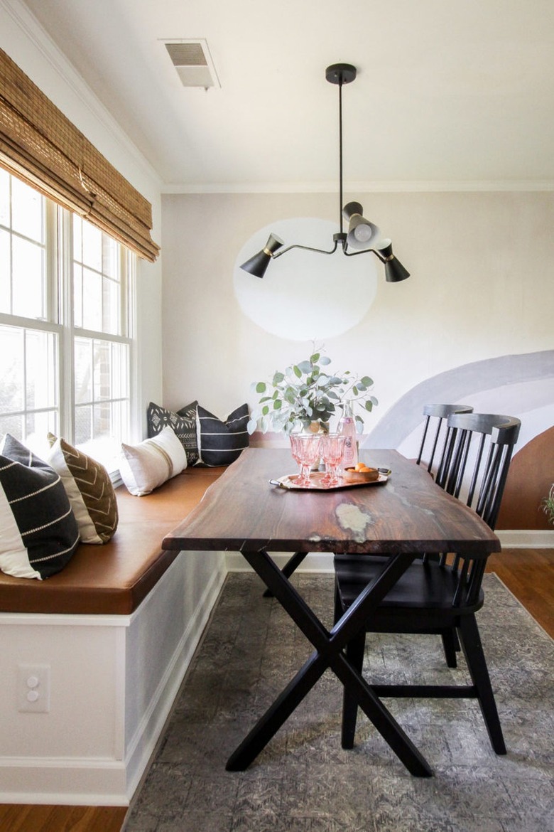 dining room with bamboo Roman shades and modern chandelier