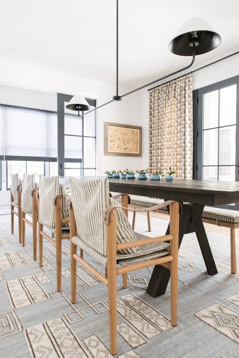 Dark wood dining room table with small vases in the middle.
