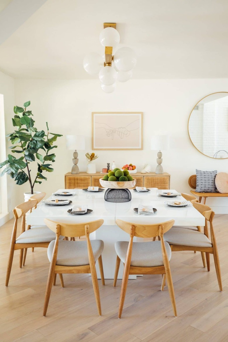 Dining room table with wood chairs and black plates.