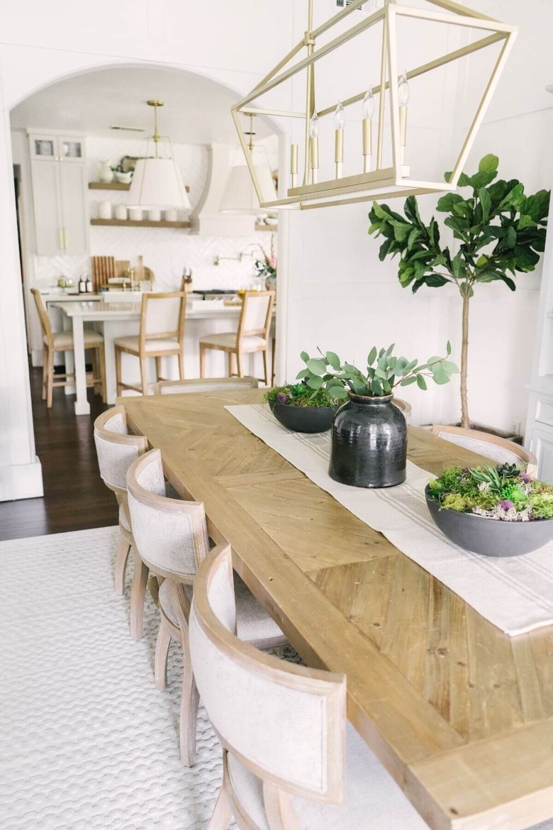 Farmhouse dining room with large table and black ceramic vases.