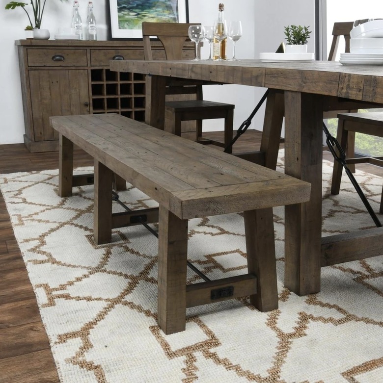 Rustic wood bench with dining table on beige patterned carpet