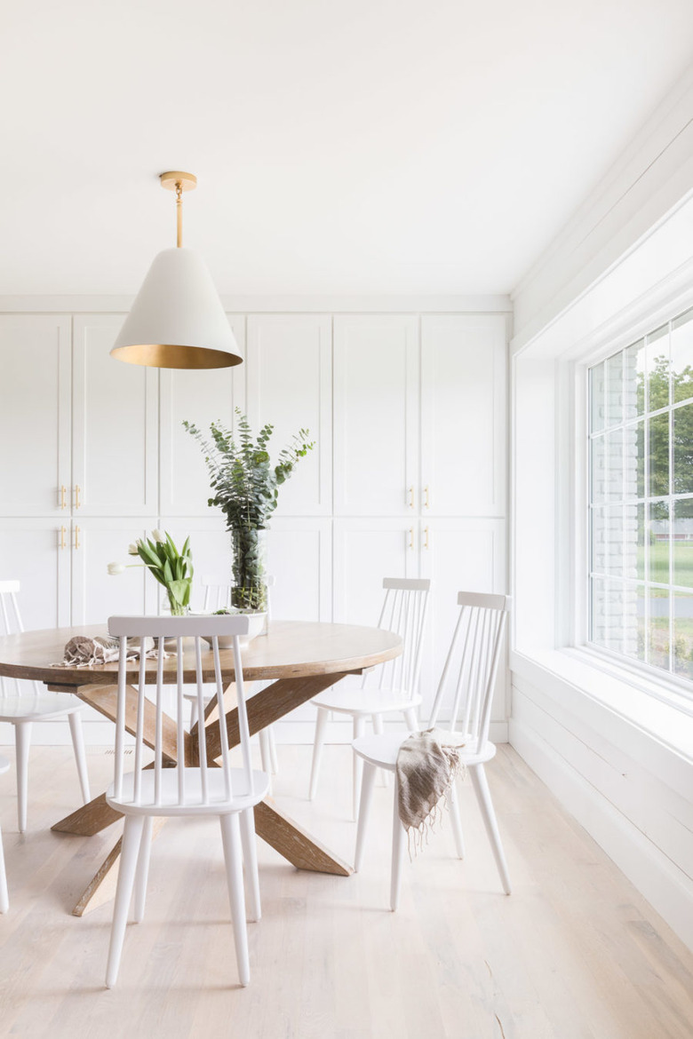 white dining room with ceiling pendant and built-in cabinetry