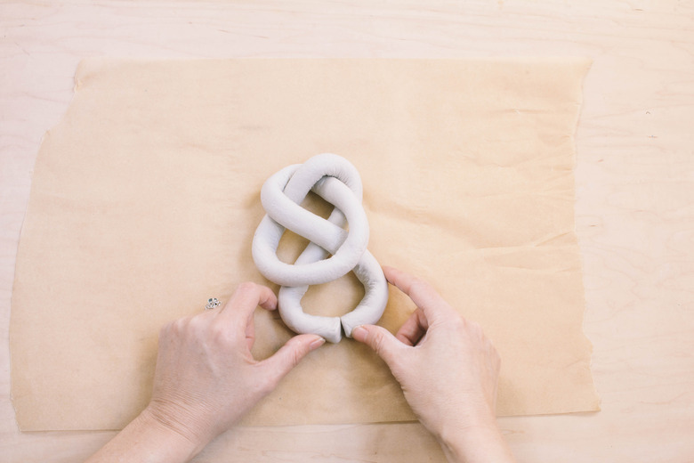 Closing tails of air dry clay sculpture to form a knot
