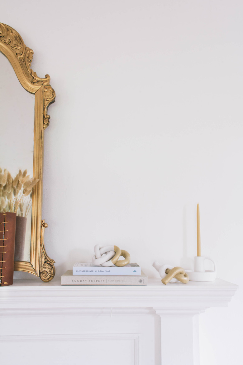 two diy clay knot sculptures on mantel with gold mirror