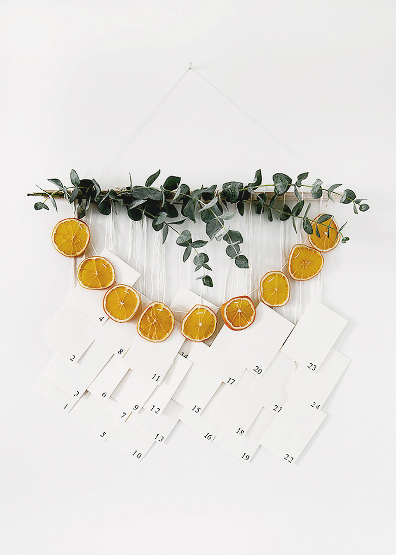 DIY Christmas decorations with white background with advent calendar featuring dried oranges and eucalyptus