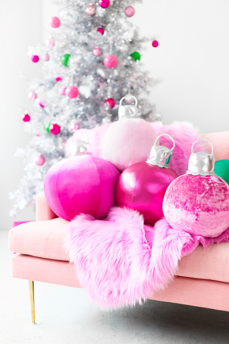 DIY Christmas decorations with pink pillow ornaments on pink sofa