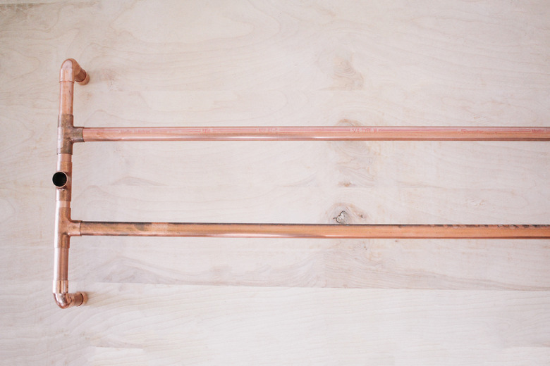 Pipes for shoe rack inserted horizontally into legs of clothing stand