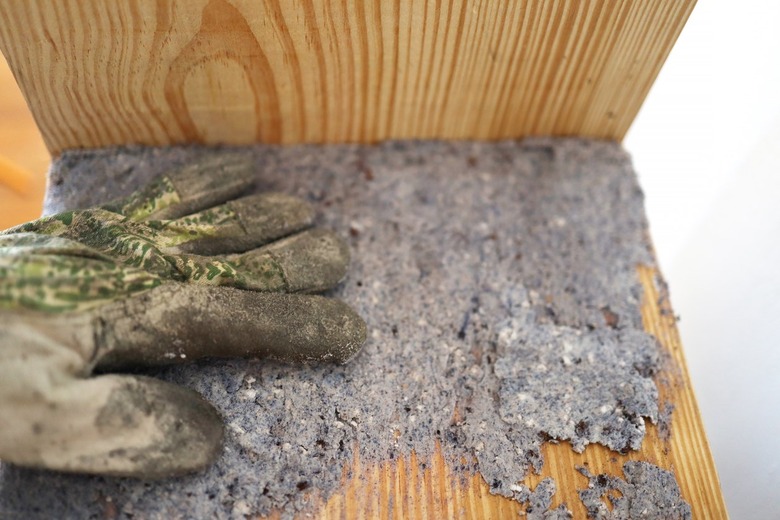 Pressing hypertufa into bench with gloved hand