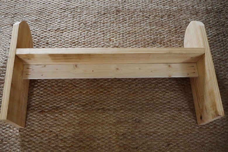 Support beam attached to bench legs underneath bench seat