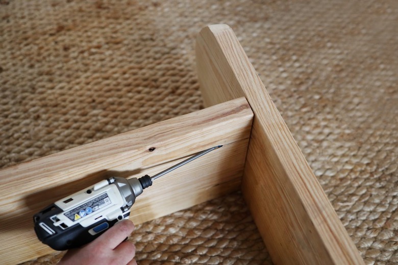 Drilling pocket hole screw into underside of bench seat into bench leg