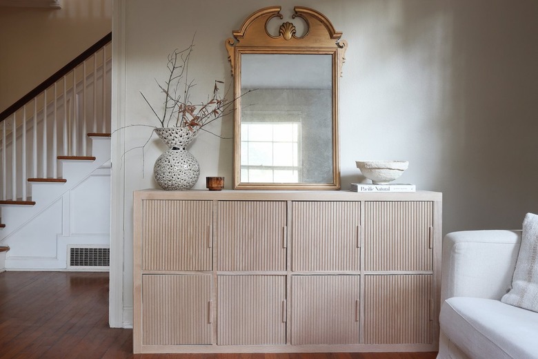 IKEA hack KALLAX shelf with fluted wood doors styled with a gold mirror