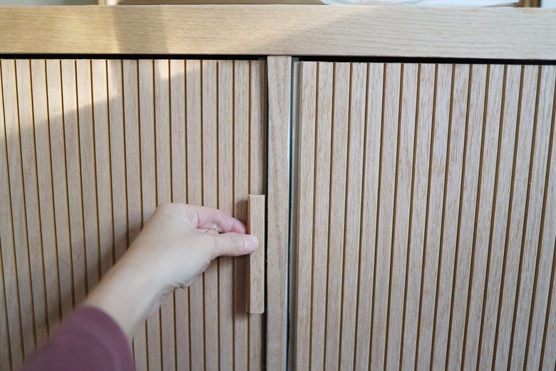 Gluing slat of pole wrap to door to serve as a handle