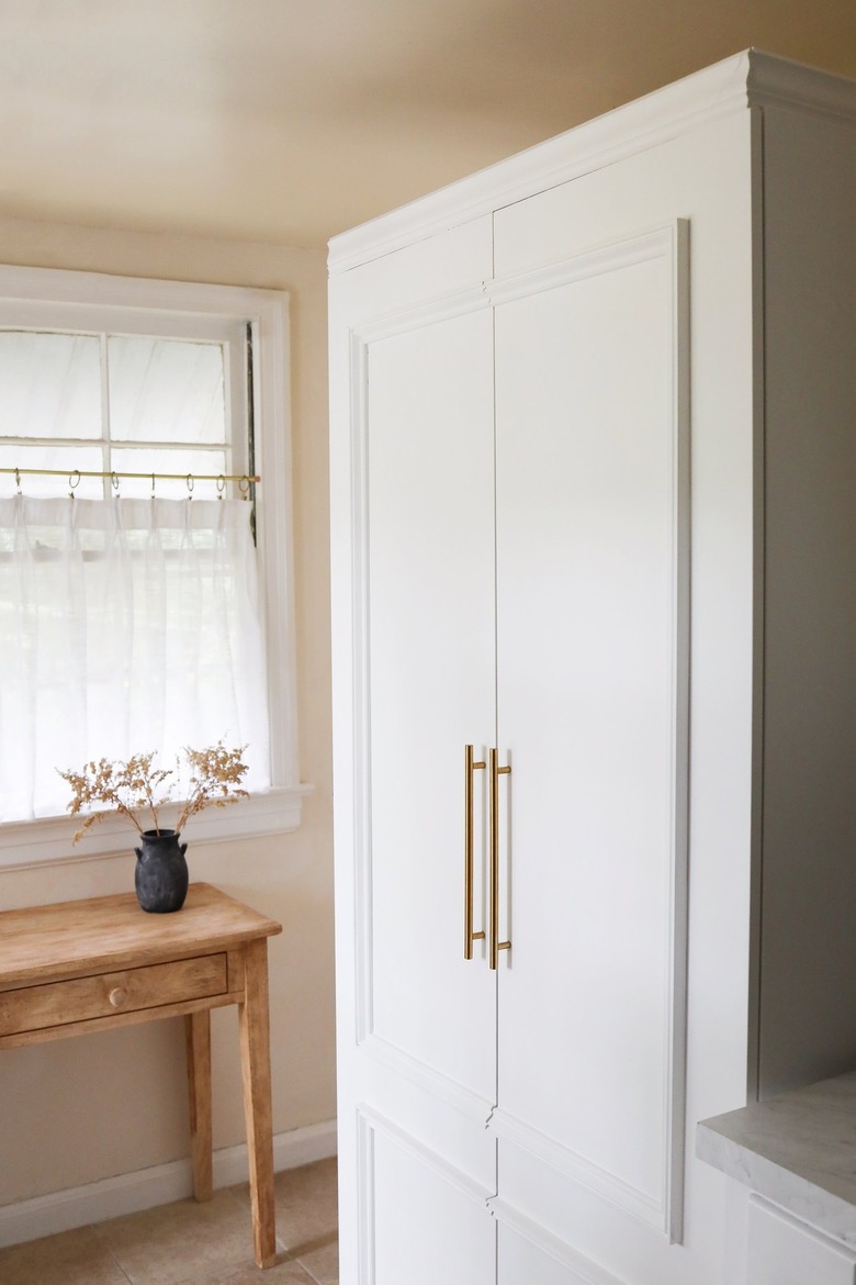 IKEA PAX pantry hack with molding and gold handles in kitchen
