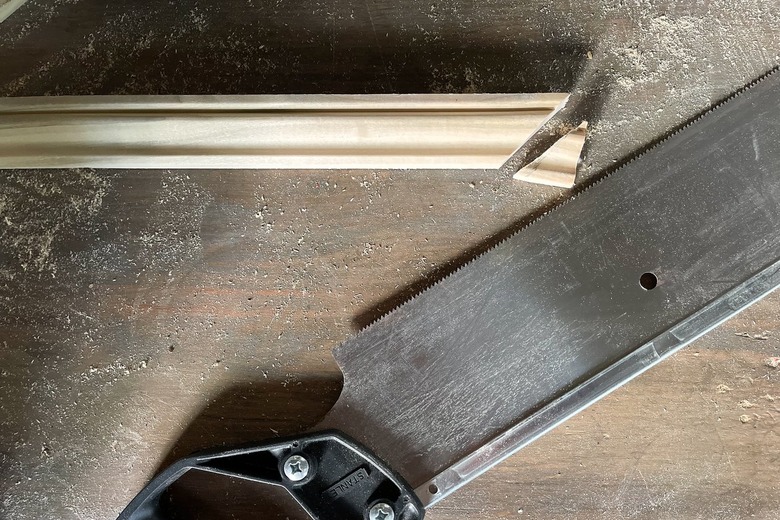 Trim molding cut to 45-degree miter angles with saw