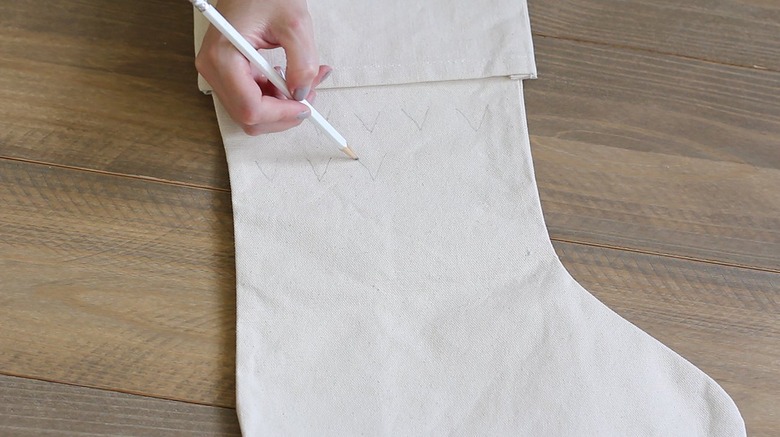 Hand penciling pattern on white stocking
