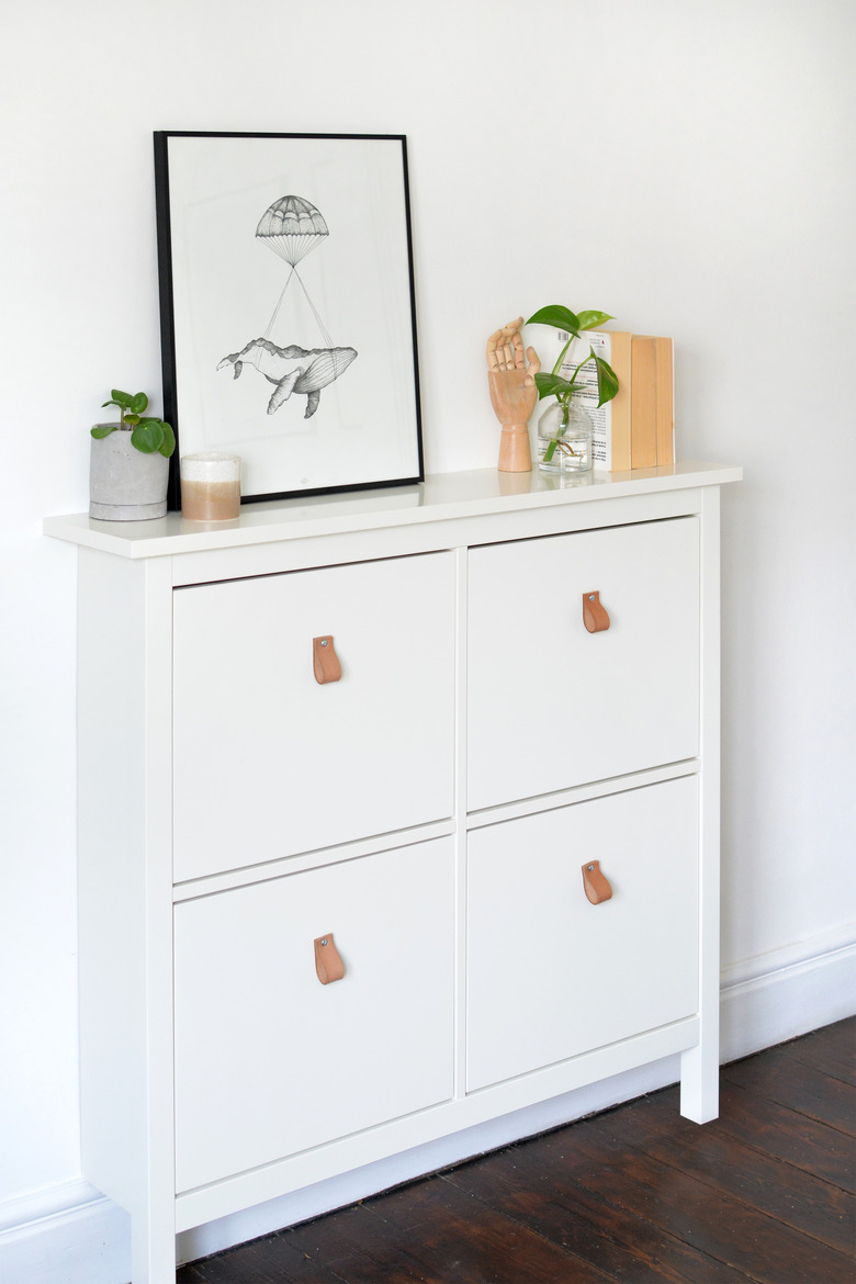 White IKEA shoe storage cabinet with framed poster