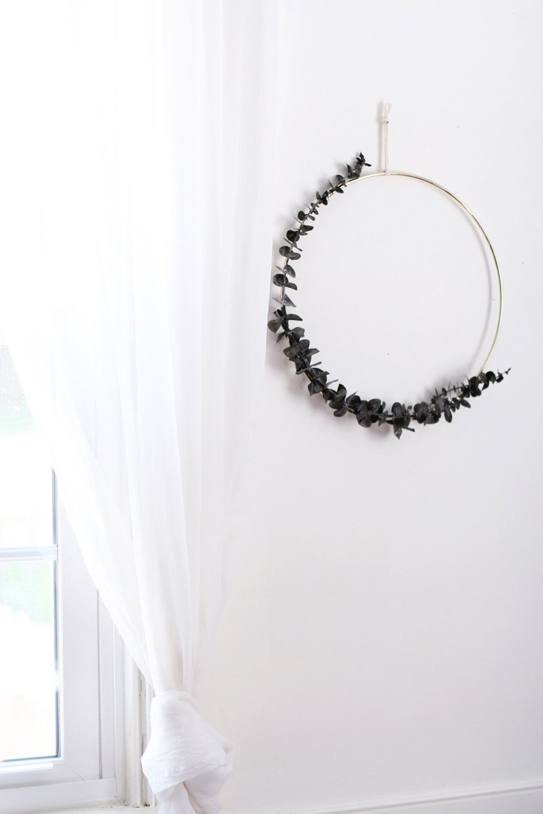 DIY minimalist wreath with eucalyptus in white room next to window