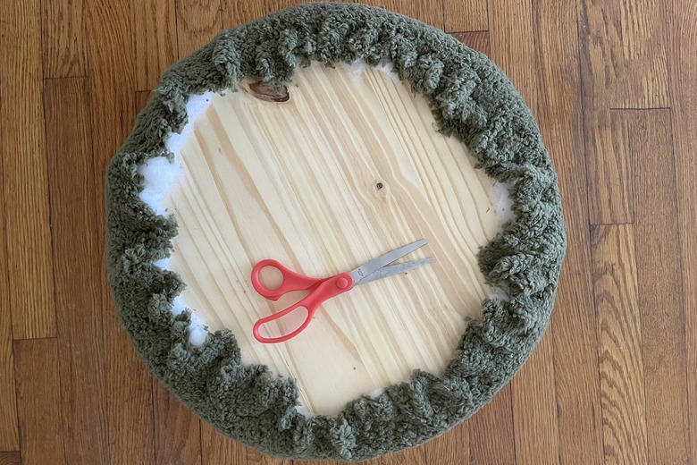 Green sherpa fabric stapled to back of wood circle