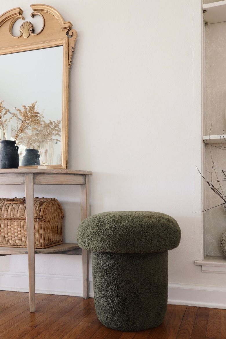 Green sherpa mushroom stool next to table with gold mirror