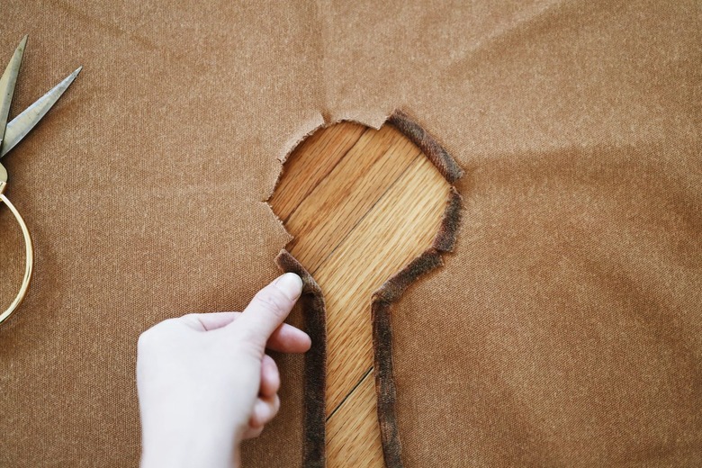 Notches cut into raw edges around center hole of fabric