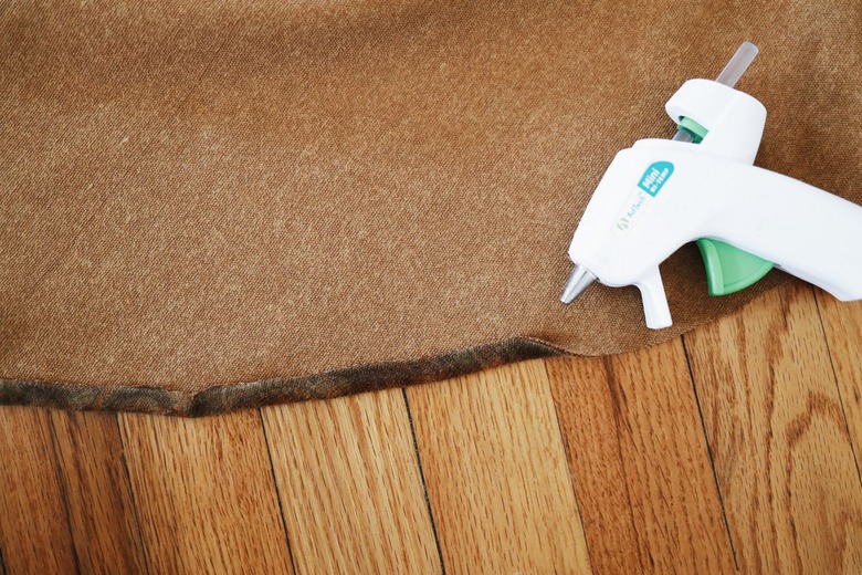 1/4 inch of brown fabric folded over and hot glued to hem raw edge