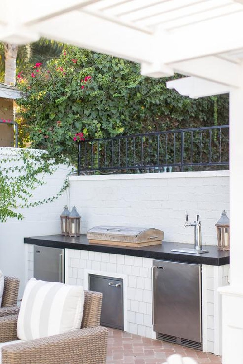 white brick and stainless steel outdoor kitchen with beer tap