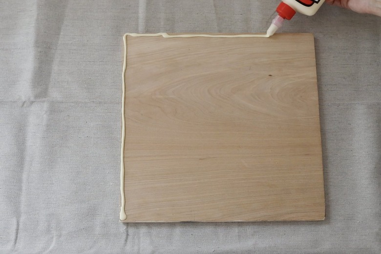 Piping wood glue along edge of wood board