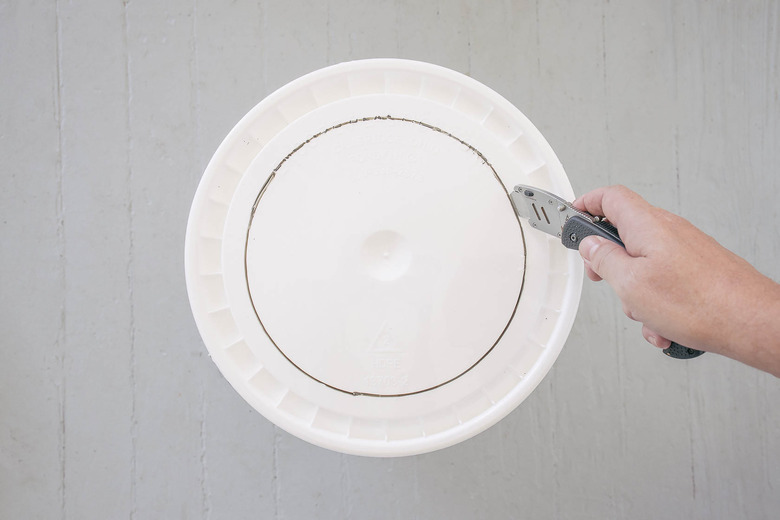 Cutting out circle on bucket lid with a box cutter