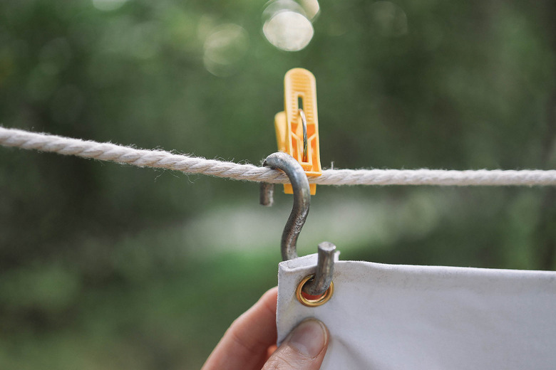 Projector screen hanging on S-hook and on rope strung outside