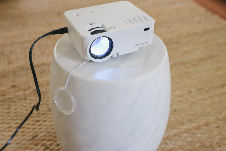 Mini projector machine set on small side table