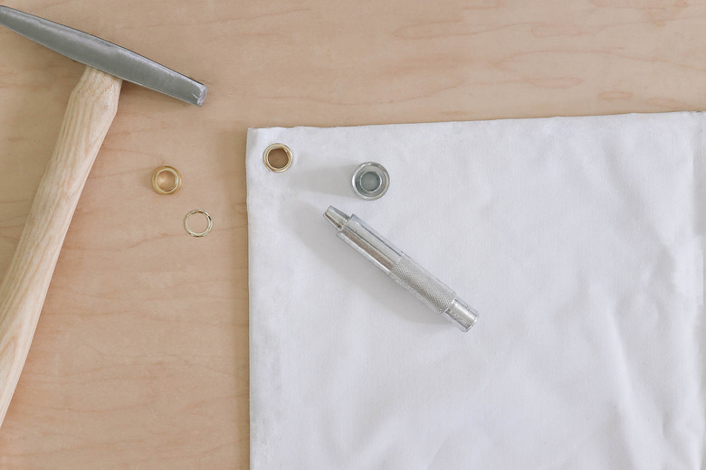 Brass grommet hammered into corner of blackout fabric