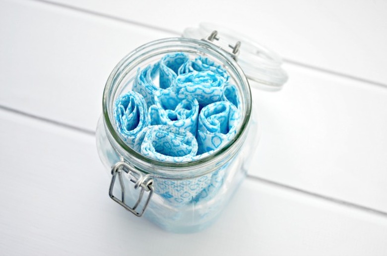 Roll each cloth and place in the container.