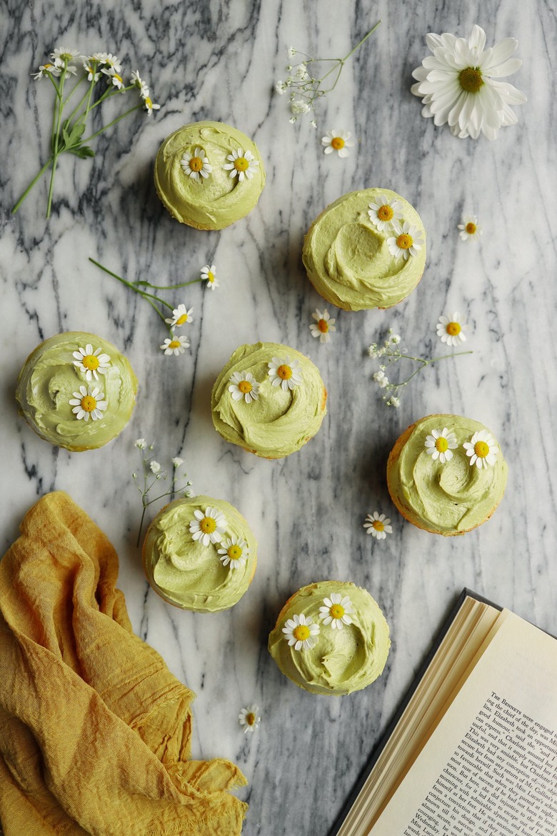 DIY sage green frosted cupcakes garnished with chamomile flowers