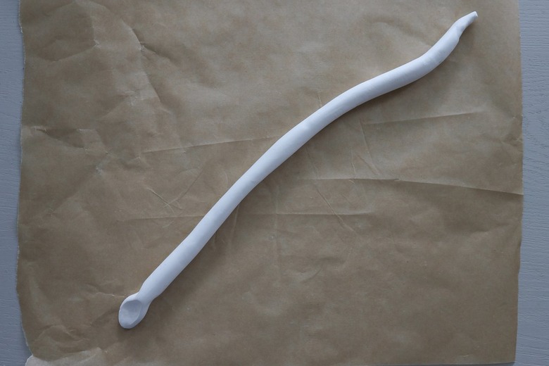 Clay log shaped into a snake head and tail at each end