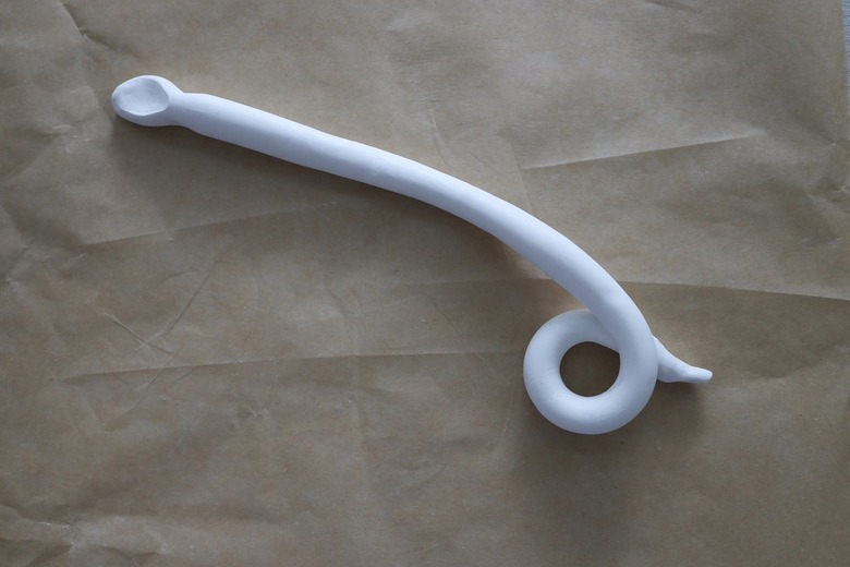 Tail end of clay snake coiled into a circle