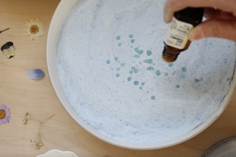 Adding drops of essential oil to shower steamers mixture