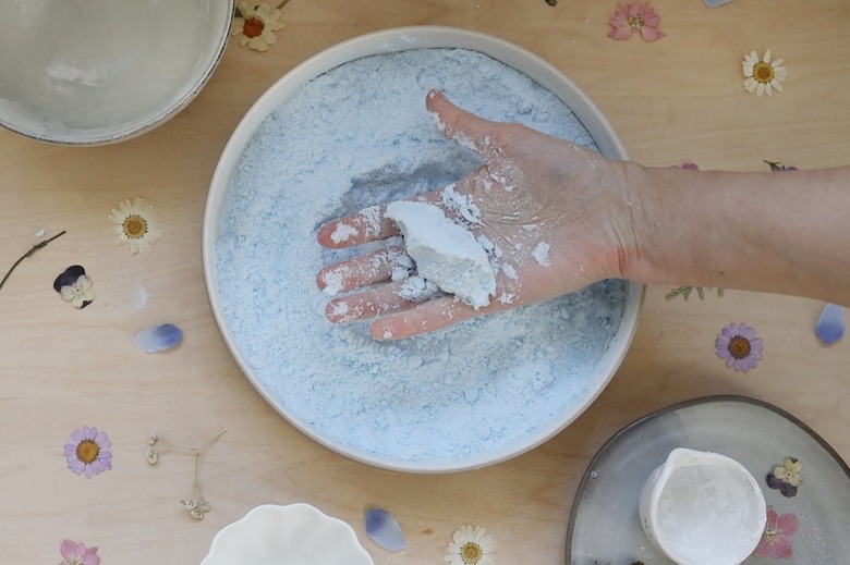 Hand holding a clump of dampened shower steamer mixture to show it holding its shape