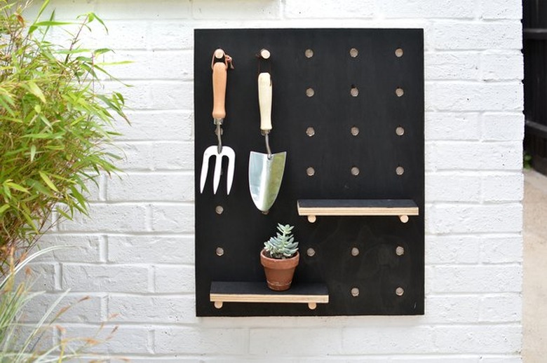 Small wall-mounted black garden tool organizer