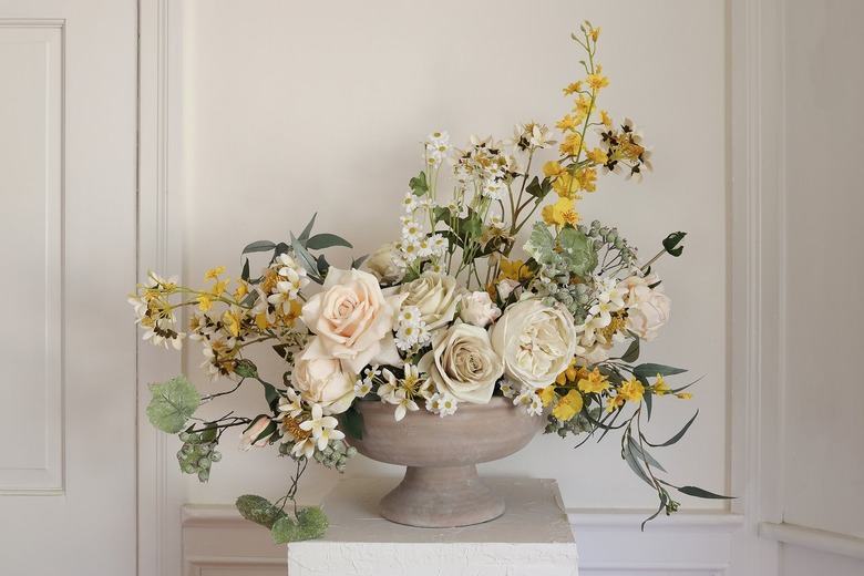 Faux seeded eucalyptus placed inside spring floral arrangement