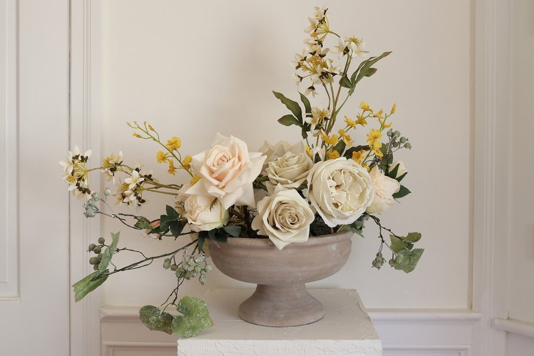 Long yellow dancing orchid stems placed inside compote bowl