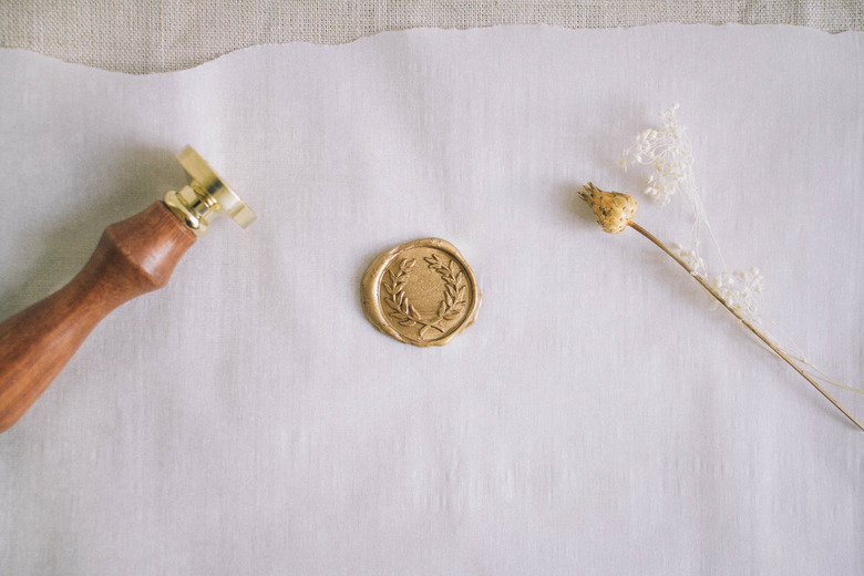 Finished gold wax seal cooling on parchment paper
