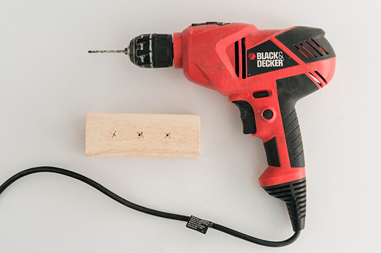 Drill pilot holes through the marks you measured out on the block of wood.