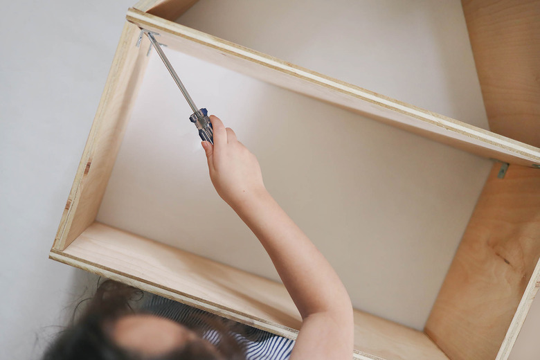 Screwing corner braces between top and bottom dollhouse pieces