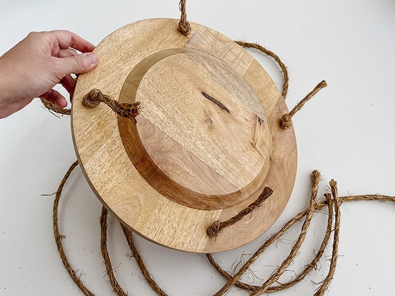 Run the knotted rope through the holes you drilled.