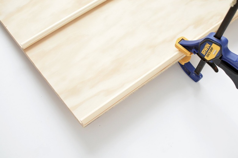 moulding that has just been glued to a plywood sheet being held in place with a clamp